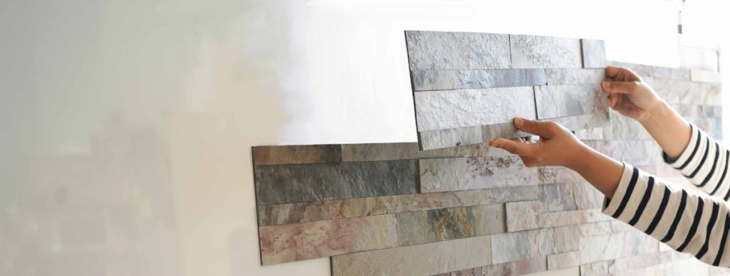 シールタイプで軽量な天然石の壁面用建材は、女性でも簡単に接着できることがわかるDIYの様子。