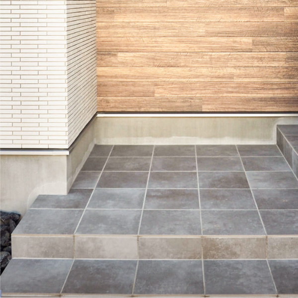 雨に濡れると黒っぽく変化が美しいグレーの玄関タイル