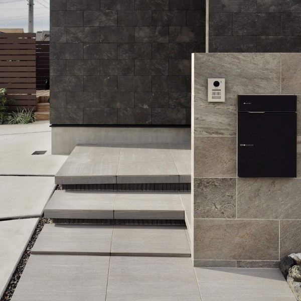 柔らかな砂岩調タイルのシエナを使用した明るいグレーの玄関