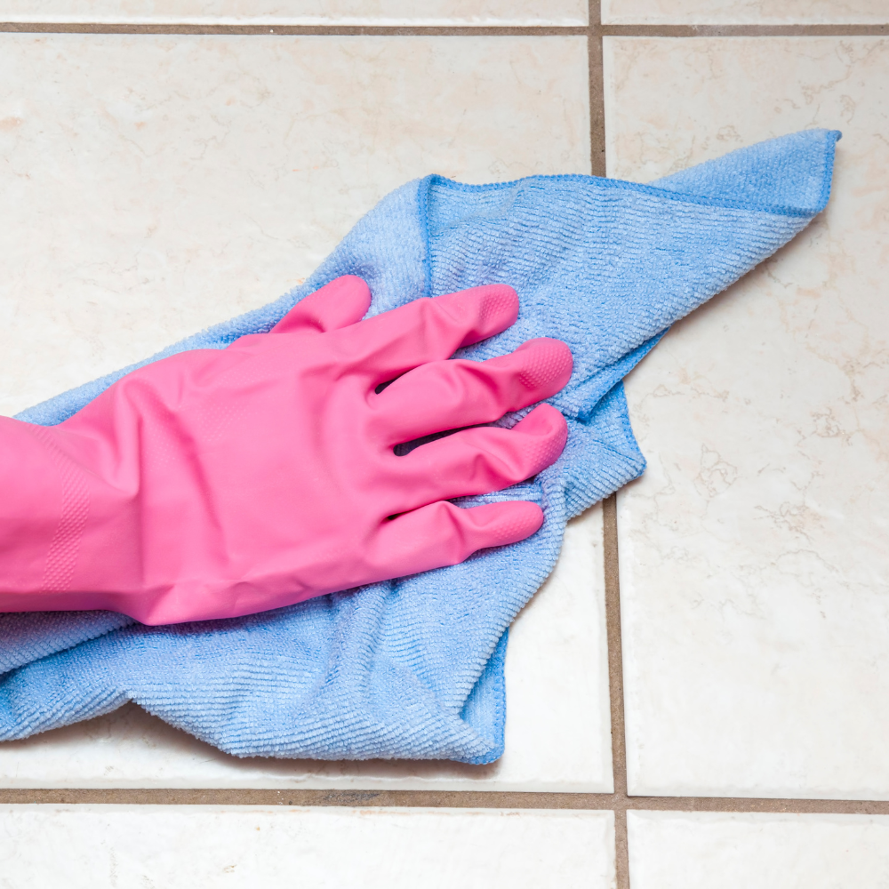 ベージュの明るい玄関タイルを掃除する手