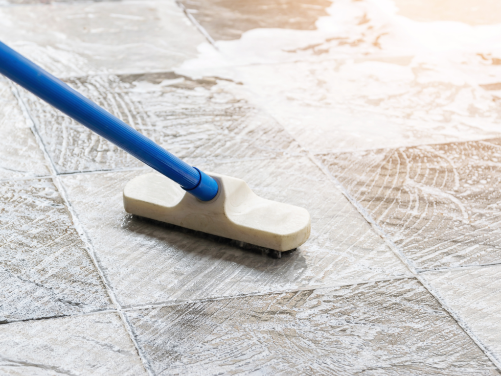 玄関タイルの掃除をするデッキブラシ