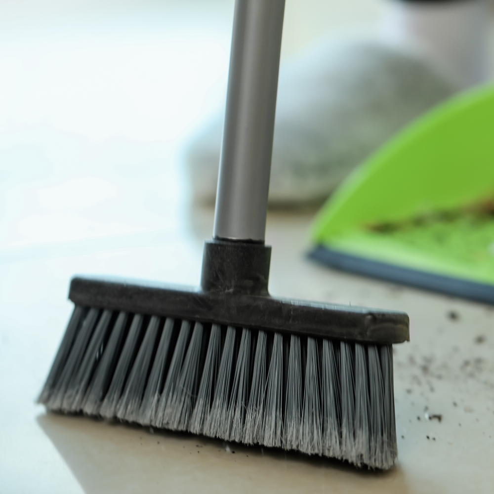 玄関の掃除をする箒と塵取り