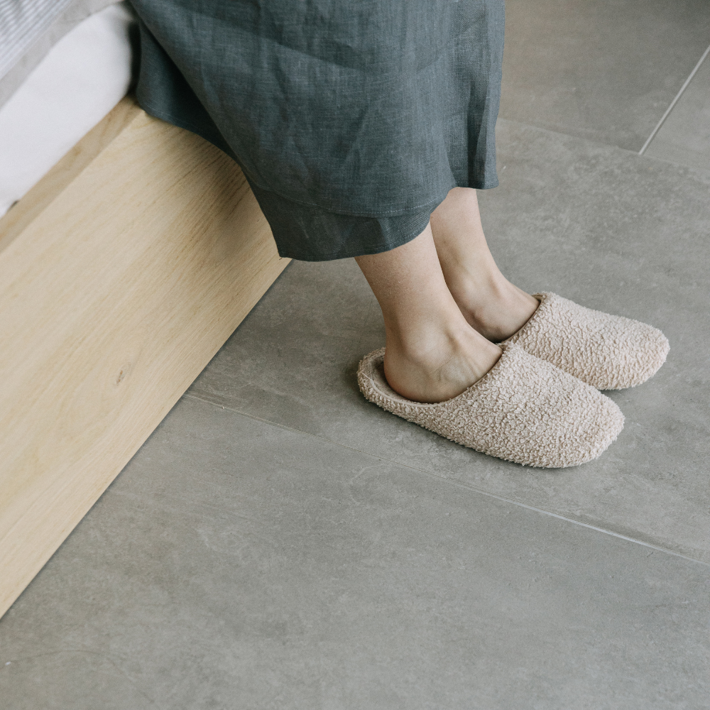 底冷えするタイルの床とスリッパをはいた人